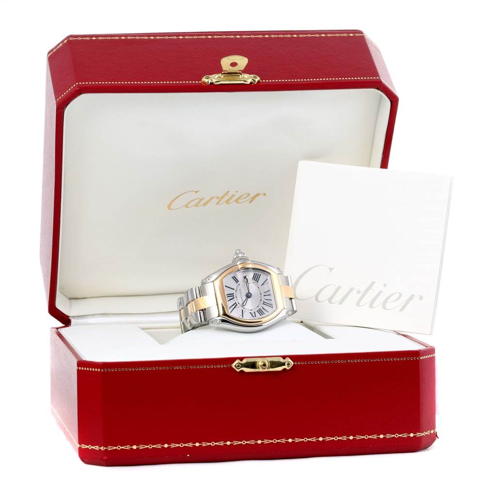 The Cartier Roadster W62026Y4 Women's Steel and Gold (two tone) Silver Dial W62026Y4 Women's Steel and Gold (two tone) Silver Dial watch is displayed at a front angle inside an open red box, accompanied by Cartier documentation.