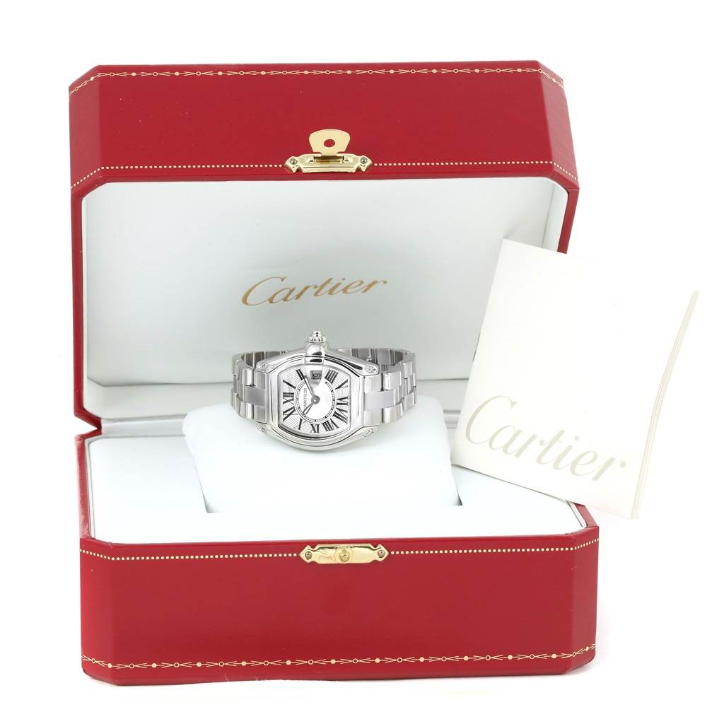 The Cartier Roadster W62016V3 Women's Stainless Steel Silver Dial W62016V3 Women's Stainless Steel Silver Dial watch is displayed front-on in its open red box with accompanying documentation on the side.