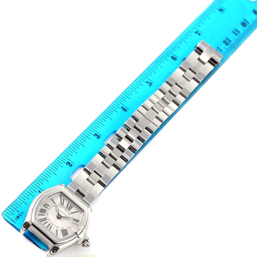 The image shows a Cartier Roadster W62016V3 Women
s Stainless Steel Silver Dial W62016V3 Women
s Stainless Steel Silver Dial watch laying flat next to a blue ruler for size reference.