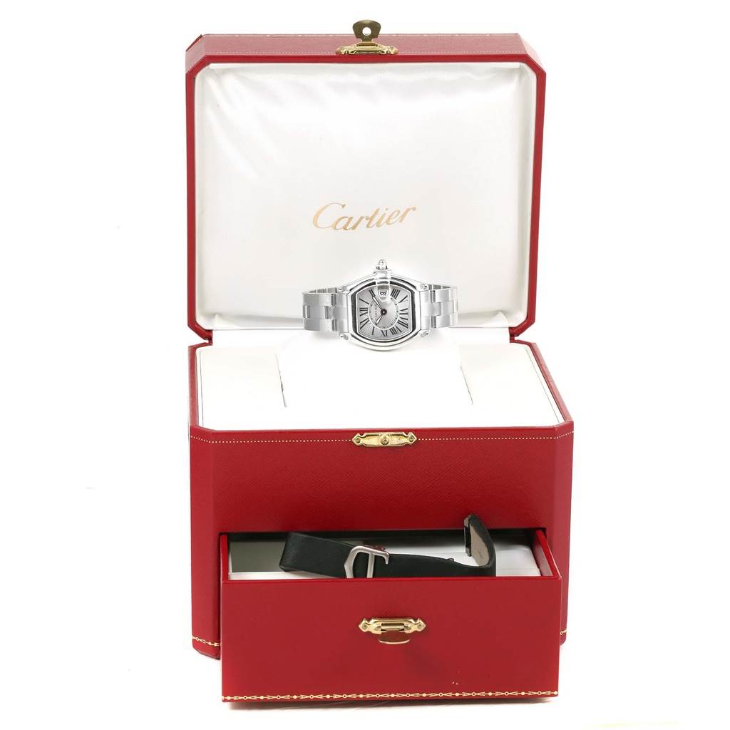 The Cartier Roadster W62016V3 Women
s Stainless Steel Silver Dial W62016V3 Women
s Stainless Steel Silver Dial watch is shown front-facing in its open box, with an extra leather strap in the drawer below.
