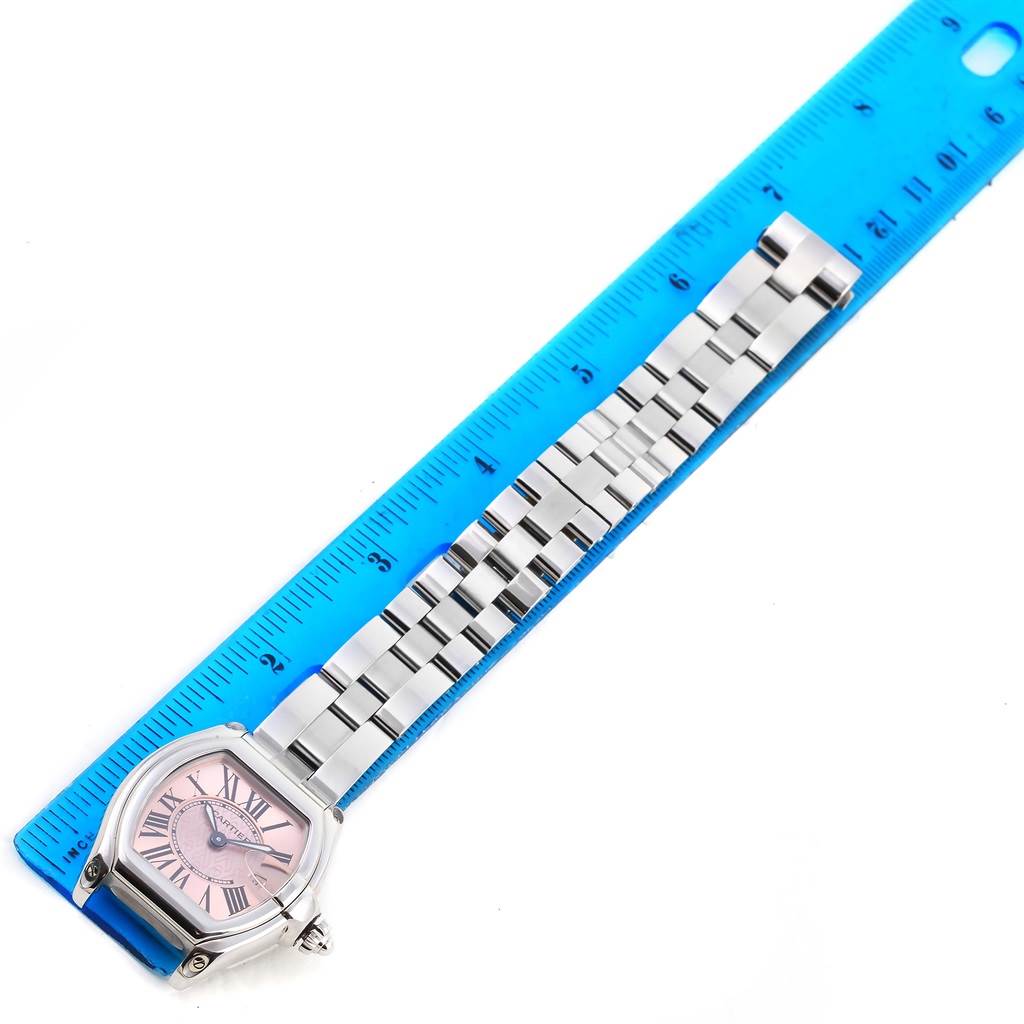 The image shows a Cartier Roadster W62043V3 Women's Stainless Steel Pink Dial W62043V3 Women's Stainless Steel Pink Dial watch face and bracelet laid next to a blue ruler.