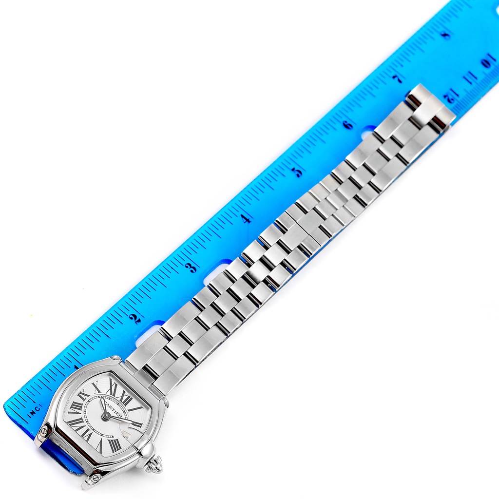 The image shows a Cartier Roadster W62016V3 Women
s Stainless Steel Silver Dial W62016V3 Women
s Stainless Steel Silver Dial watch laid flat next to a ruler, displaying the face and metal bracelet.