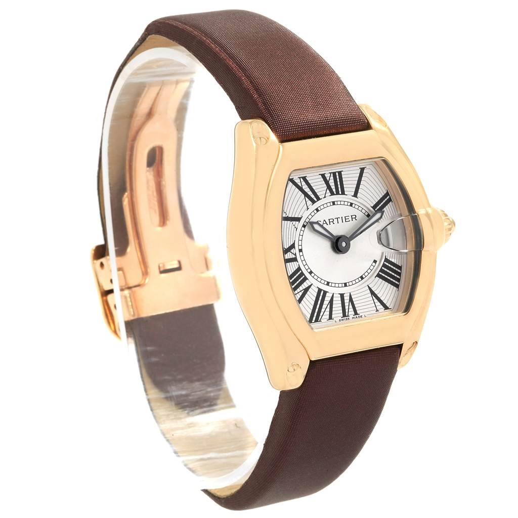 The image shows a side view of a Cartier Roadster W62018Y5 Women's Yellow Gold Silver Dial W62018Y5 Women's Yellow Gold Silver Dial watch, displaying its brown strap, gold case, and Roman numeral dial.