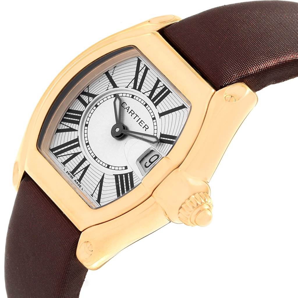 The Cartier Roadster W62018Y5 Women's Yellow Gold Silver Dial W62018Y5 Women's Yellow Gold Silver Dial watch is shown from a slightly tilted side angle, highlighting its face, case, and strap.