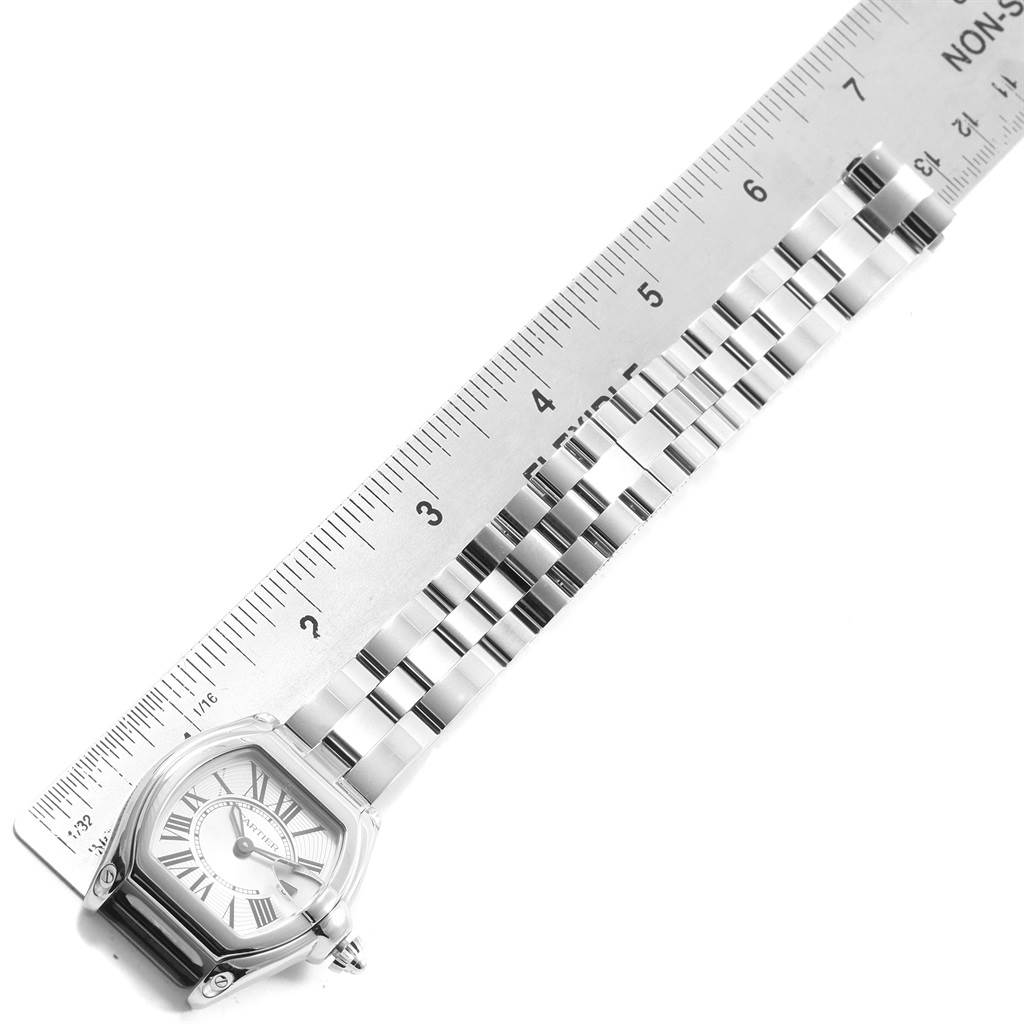 The Cartier Roadster W62016V3 Women
s Stainless Steel Silver Dial W62016V3 Women
s Stainless Steel Silver Dial watch is shown lying flat alongside a ruler, displaying its face, case, and stainless steel bracelet.