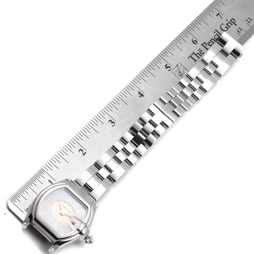 The image shows a top-down view of a Cartier Roadster W62053V3 Women's Stainless Steel Blue Dial W62053V3 Women's Stainless Steel Blue Dial watch with its face and bracelet next to a ruler.