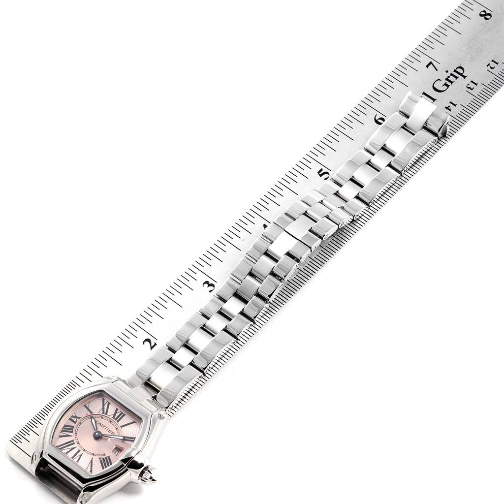 The Cartier Roadster W62017V3 Women
s Stainless Steel Pink Dial W62017V3 Women
s Stainless Steel Pink Dial watch is shown from an overhead angle, displaying the dial, part of the bracelet, and a ruler.