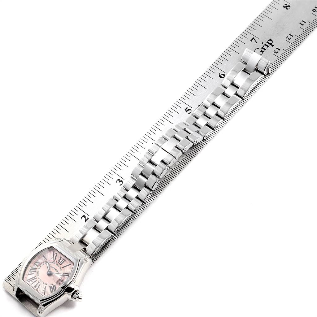 The image shows a Cartier Roadster W62017V3 Women's Stainless Steel Pink Dial W62017V3 Women's Stainless Steel Pink Dial watch at an angled top-down view, focusing on its face and metal bracelet next to a ruler.