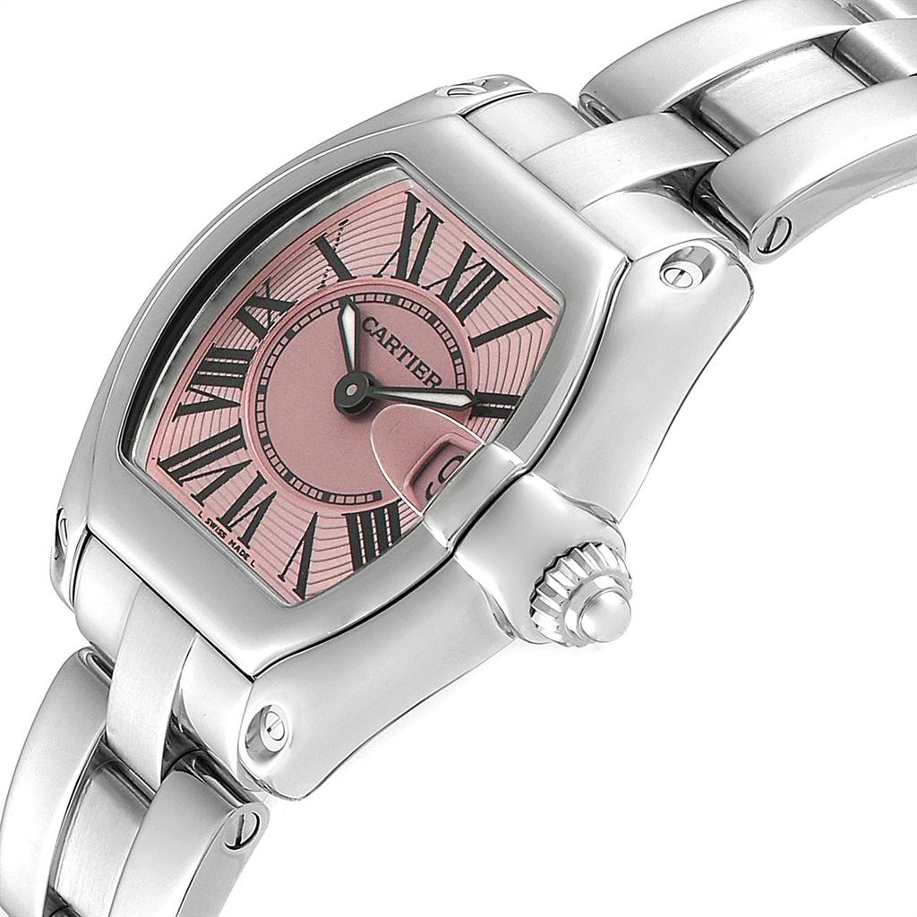 The image shows a close-up angle of the Cartier Roadster W62017V3 Women's Stainless Steel Pink Dial W62017V3 Women's Stainless Steel Pink Dial watch, highlighting its pink dial, Roman numerals, and metal bracelet.