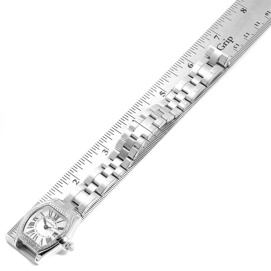 The image shows a top view of a Cartier Roadster WE5002X2 Women's White Gold Silver Dial WE5002X2 Women's White Gold Silver Dial watch face and bracelet aligned with a ruler.