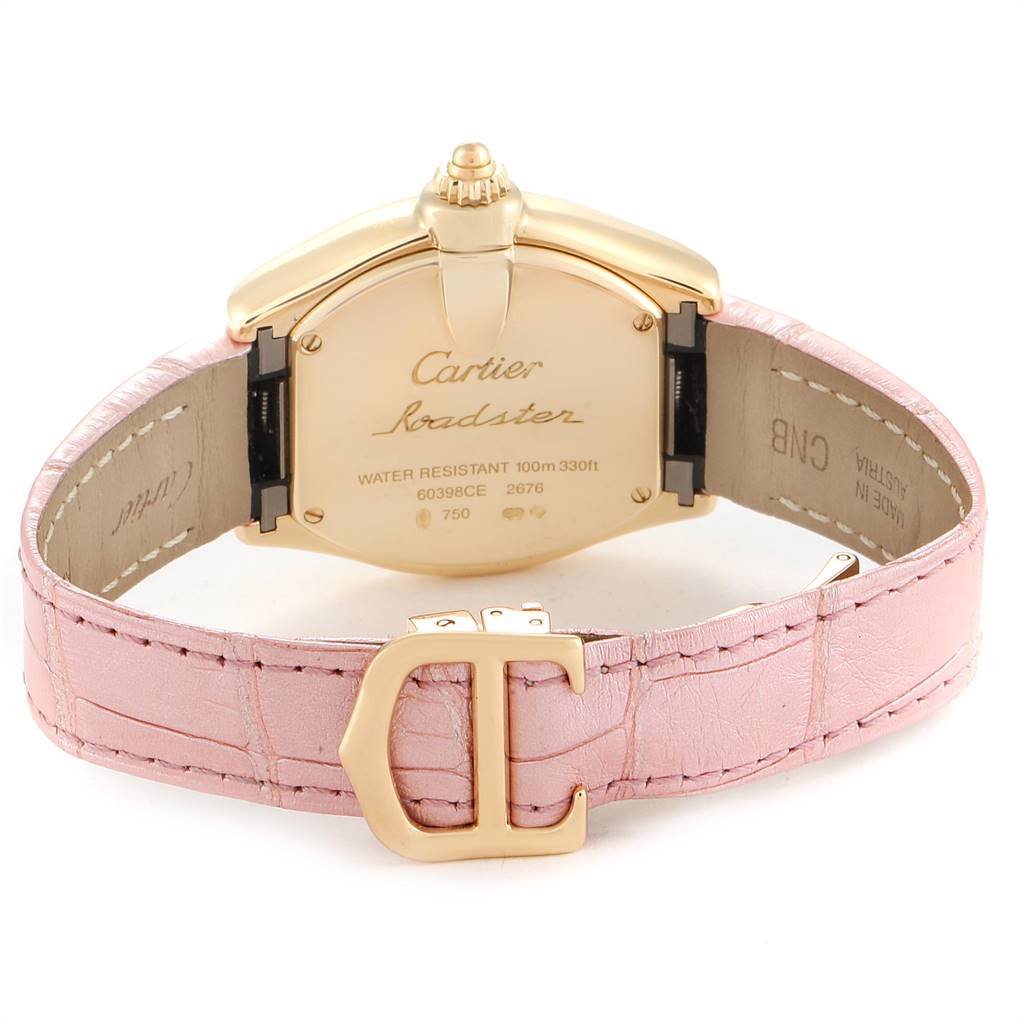 This Cartier Roadster W62018Y5 Women
s Yellow Gold Silver Dial W62018Y5 Women
s Yellow Gold Silver Dial watch is shown from the back, highlighting its case, engraving, and pink leather strap with a clasp.