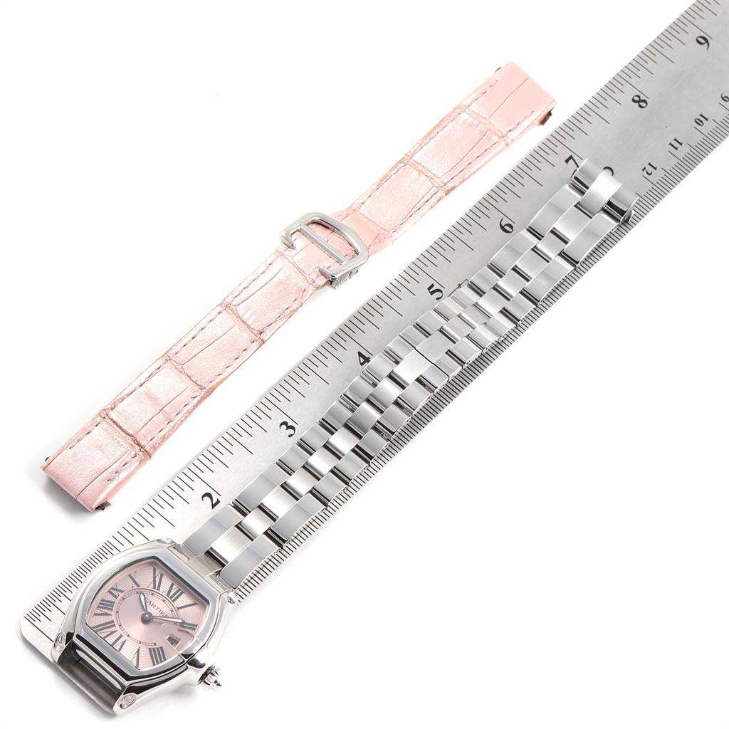This image shows a Cartier Roadster W62017V3 Women's Stainless Steel Pink Dial W62017V3 Women's Stainless Steel Pink Dial watch face with a metal bracelet and a pink leather strap, alongside a ruler for scale.