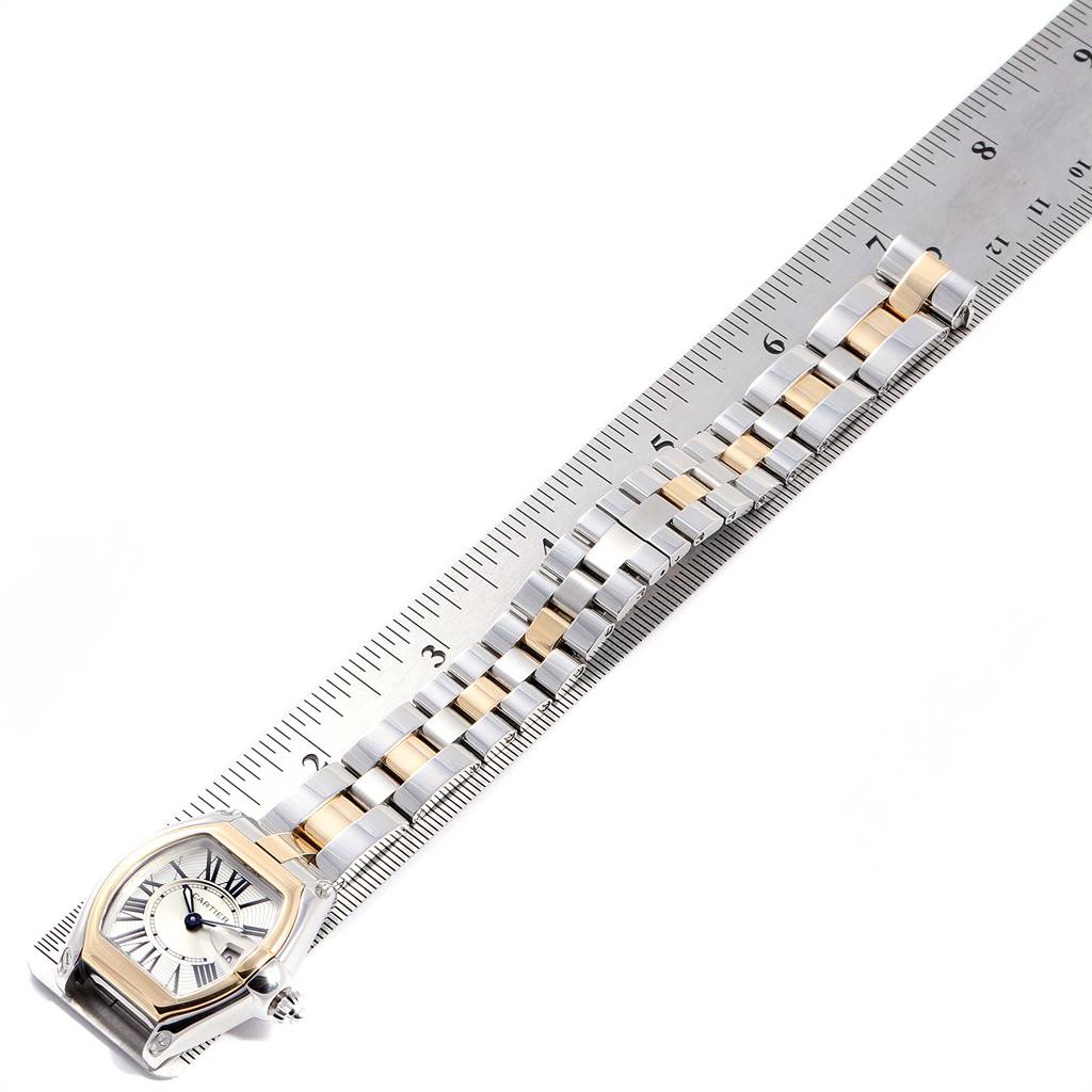 The Cartier Roadster W62026Y4 Women's Steel and Gold (two tone) Silver Dial W62026Y4 Women's Steel and Gold (two tone) Silver Dial watch is shown at a top-down angle with the face and band visible, alongside a ruler for scale.