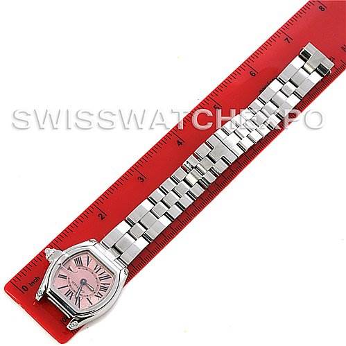 This image shows the top view of a Cartier Roadster W62017V3 Women's Stainless Steel Pink Dial W62017V3 Women's Stainless Steel Pink Dial watch and its metal strap against a red ruler for scale.