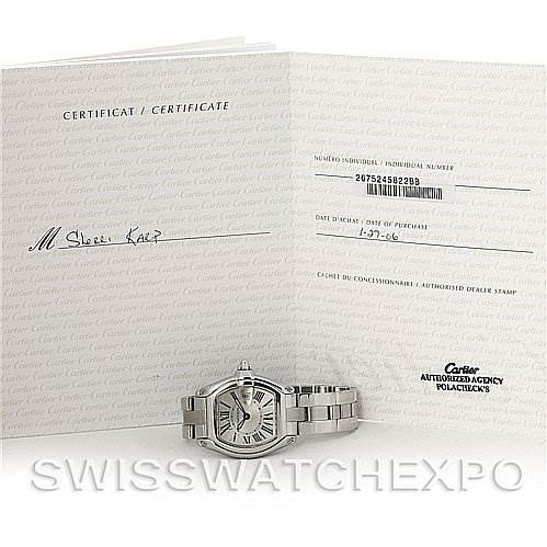 The image shows a Cartier Roadster W62016V3 Women
s Stainless Steel Silver Dial W62016V3 Women
s Stainless Steel Silver Dial watch laid flat with its certificate of Best Quality
ity open behind it.
