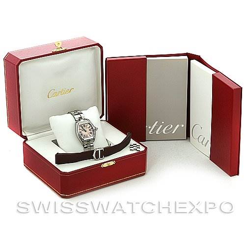 The image shows a Cartier Roadster W62017V3 Women's Stainless Steel Pink Dial W62017V3 Women's Stainless Steel Pink Dial watch in its box, with an extra strap and accompanying documents.