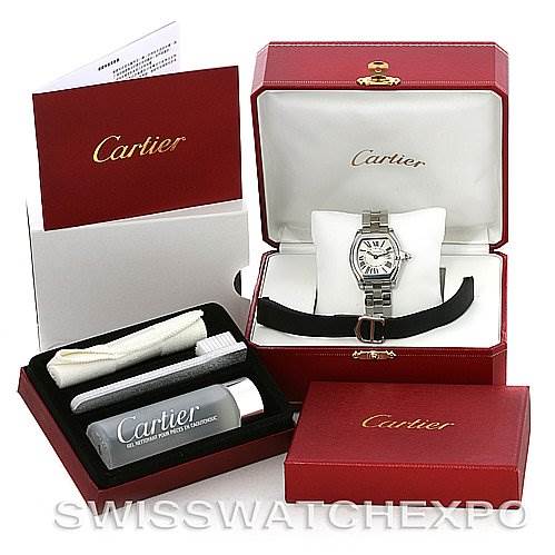 The image shows the Cartier Roadster W62016V3 Women
s Stainless Steel Silver Dial W62016V3 Women
s Stainless Steel Silver Dial watch with its accessories, including a strap, box, manual, cleaning cloth, and cleaning solution.