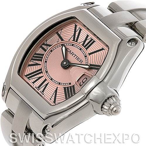 The image shows a Cartier Roadster W62017V3 Women
s Stainless Steel Pink Dial W62017V3 Women
s Stainless Steel Pink Dial watch at a slight angle, highlighting the pink dial, Roman numerals, crown, and part of the stainless steel bracelet.