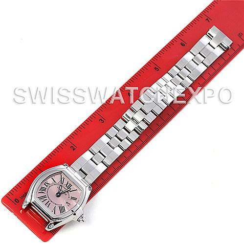 The Cartier Roadster W62017V3 Women
s Stainless Steel Pink Dial W62017V3 Women
s Stainless Steel Pink Dial watch is displayed fully, featuring its face, case, and metal bracelet on a red ruler backdrop.