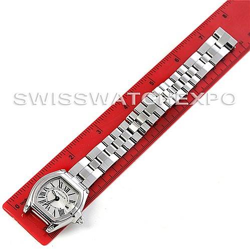 The image shows a Cartier Roadster W62016V3 Women's Stainless Steel Silver Dial W62016V3 Women's Stainless Steel Silver Dial watch laid flat on a red ruler, displaying its face, case, and stainless steel bracelet.
