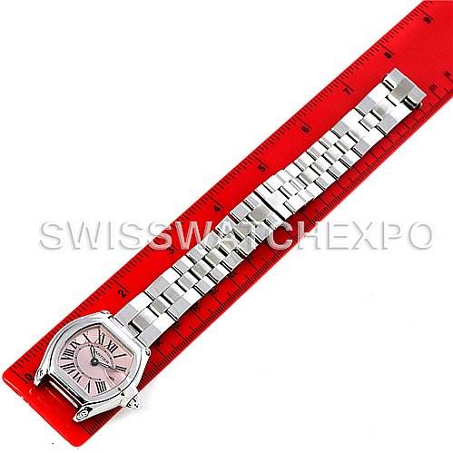 The Cartier Roadster W62017V3 Women
s Stainless Steel Pink Dial W62017V3 Women
s Stainless Steel Pink Dial watch is shown from a top-down angle, displaying its face, bracelet, and a partial ruler for scale.