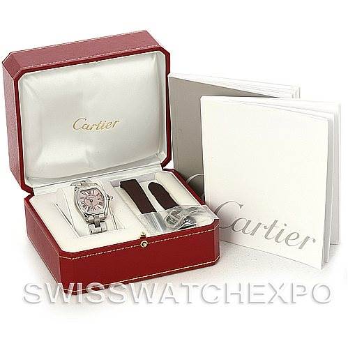 The image shows a Cartier Roadster W62017V3 Women
s Stainless Steel Pink Dial W62017V3 Women
s Stainless Steel Pink Dial watch and includes additional straps, an unopened book, and a red Cartier box.