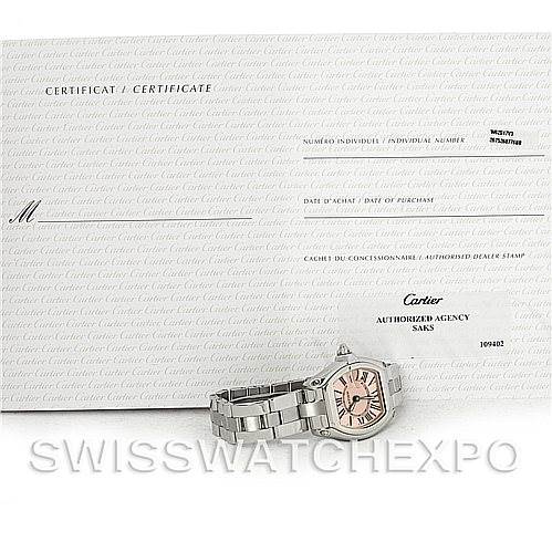 A Cartier Roadster W62017V3 Women
s Stainless Steel Pink Dial W62017V3 Women
s Stainless Steel Pink Dial watch is displayed at a slight angle in front of its certificate and authorization card.