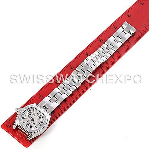 The image shows a Cartier Roadster W62016V3 Women
s Stainless Steel Silver Dial W62016V3 Women
s Stainless Steel Silver Dial watch laid flat on a red ruler, displaying its face, bracelet, and clasp.
