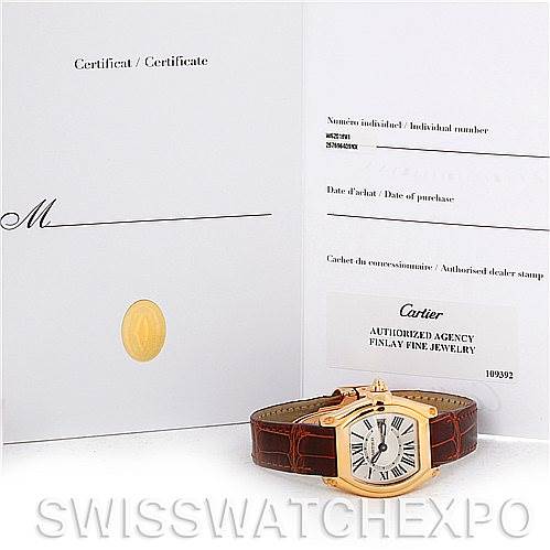The image shows a Cartier Roadster W62018Y5 Women's Yellow Gold Silver Dial W62018Y5 Women's Yellow Gold Silver Dial watch lay flat with its certificate and warranty card displayed upright in the background.