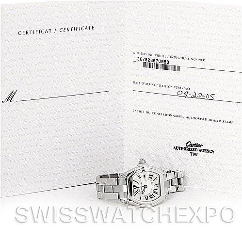 The image shows a Cartier Roadster W62016V3 Women
s Stainless Steel Silver Dial W62016V3 Women
s Stainless Steel Silver Dial watch displayed at a slight angle with its certificate in the background.