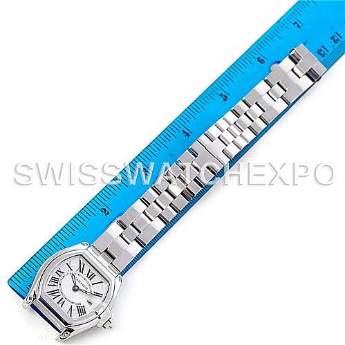 The image shows a Cartier Roadster W62016V3 Women
s Stainless Steel Silver Dial W62016V3 Women
s Stainless Steel Silver Dial watch laid flat next to a blue ruler, highlighting the watch face and metal bracelet.