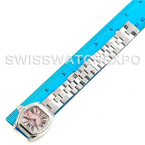The Cartier Roadster W62017V3 Women's Stainless Steel Pink Dial W62017V3 Women's Stainless Steel Pink Dial watch is shown from a top view, displaying its face, bracelet, and part of the bezel, aligned with a blue ruler.