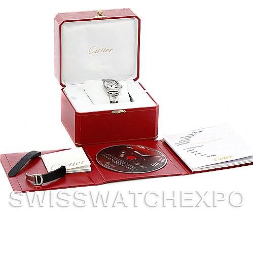 This image shows a Cartier Roadster W62016V3 Women's Stainless Steel Silver Dial W62016V3 Women's Stainless Steel Silver Dial watch and its accessories from an overhead angle, including the box, manual, extra strap, and CD.