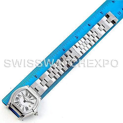 The image shows the Cartier Roadster W62016V3 Women's Stainless Steel Silver Dial W62016V3 Women's Stainless Steel Silver Dial watch laying flat next to a blue ruler, displaying its face and stainless steel bracelet.