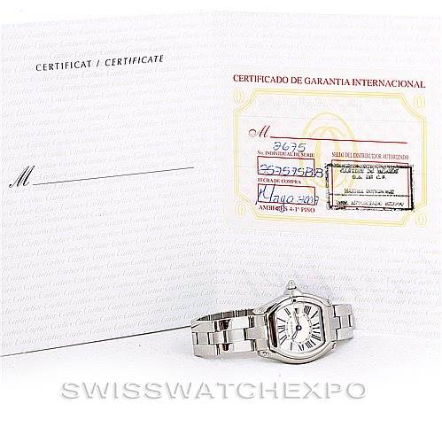 The image shows a Cartier Roadster W62016V3 Women's Stainless Steel Silver Dial W62016V3 Women's Stainless Steel Silver Dial watch laid flat with an open warranty certificate behind it.