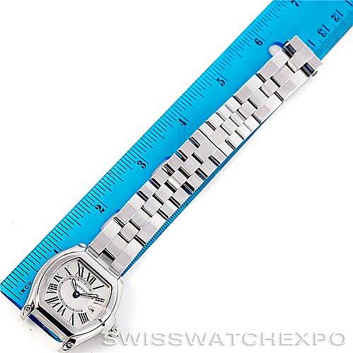 The Cartier Roadster W62016V3 Women's Stainless Steel Silver Dial W62016V3 Women's Stainless Steel Silver Dial watch face and bracelet are shown from an overhead angle next to a blue ruler.