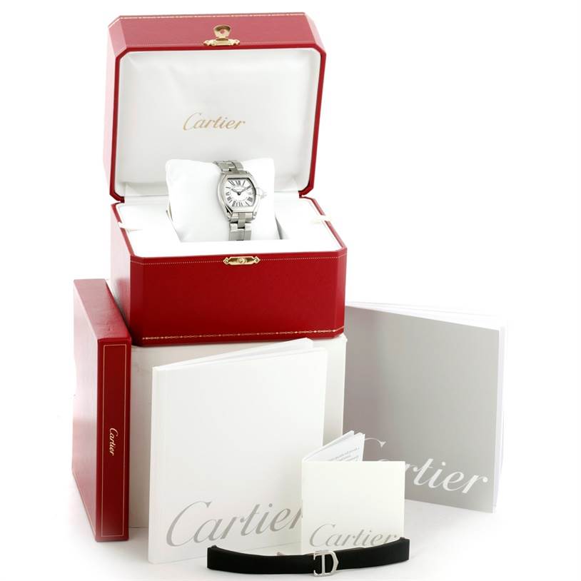 The Cartier Roadster W62016V3 Women's Stainless Steel Silver Dial W62016V3 Women's Stainless Steel Silver Dial watch is shown front-facing in its open red box with accompanying booklets and additional accessories.