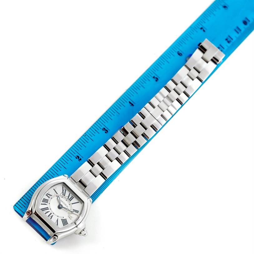 The image shows a Cartier Roadster W62016V3 Women's Stainless Steel Silver Dial W62016V3 Women's Stainless Steel Silver Dial watch laid flat with its face and metal bracelet visible beside a blue ruler.