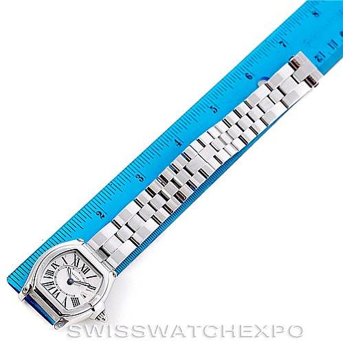 This image shows a Cartier Roadster W62016V3 Women's Stainless Steel Silver Dial W62016V3 Women's Stainless Steel Silver Dial watch laid flat alongside a blue ruler, highlighting its face and stainless steel bracelet.