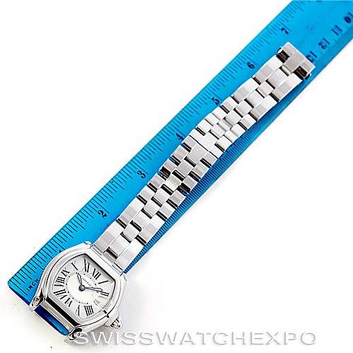 The Cartier Roadster W62016V3 Women's Stainless Steel Silver Dial W62016V3 Women's Stainless Steel Silver Dial watch is shown with its face and bracelet, alongside a blue ruler for scale.