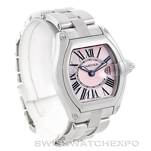 The Cartier Roadster W62017V3 Women's Stainless Steel Pink Dial W62017V3 Women's Stainless Steel Pink Dial model watch is shown at an angled view, displaying its case, pink dial with Roman numerals, and metal bracelet.