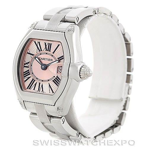 The image shows a three-quarter angle of a Cartier Roadster W62017V3 Women's Stainless Steel Pink Dial W62017V3 Women's Stainless Steel Pink Dial watch, highlighting its pink dial, Roman numerals, and stainless steel bracelet.