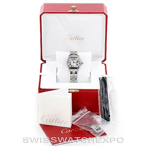 The image shows a Cartier Roadster W62016V3 Women's Stainless Steel Silver Dial W62016V3 Women's Stainless Steel Silver Dial watch in its open box with accessories such as a booklet, additional strap, and parts.