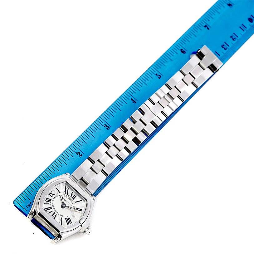 The Cartier Roadster W62016V3 Women's Stainless Steel Silver Dial W62016V3 Women's Stainless Steel Silver Dial watch is shown from a top-down angle with the face and full bracelet visible, placed alongside a blue ruler.