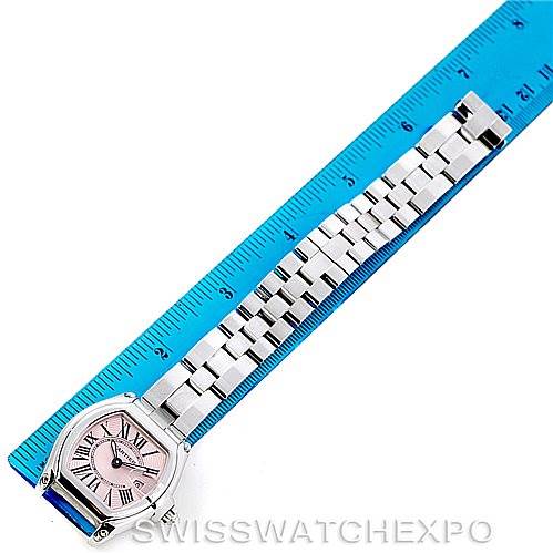 The Cartier Roadster W62017V3 Women's Stainless Steel Pink Dial W62017V3 Women's Stainless Steel Pink Dial watch is shown lying flat, illustrating the face, bracelet, and a blue ruler for size reference.