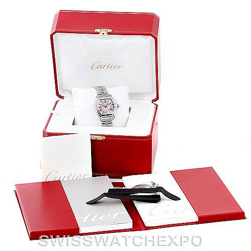 The image shows a Cartier Roadster W62017V3 Women's Stainless Steel Pink Dial W62017V3 Women's Stainless Steel Pink Dial watch in a red box, with an extra strap, tool, and paperwork laid out in front.