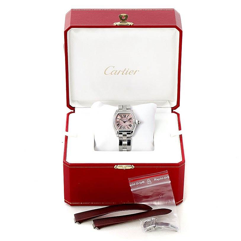 The Cartier Roadster W62017V3 Women's Stainless Steel Pink Dial W62017V3 Women's Stainless Steel Pink Dial watch is shown from the front in its box with additional straps and a clasp.