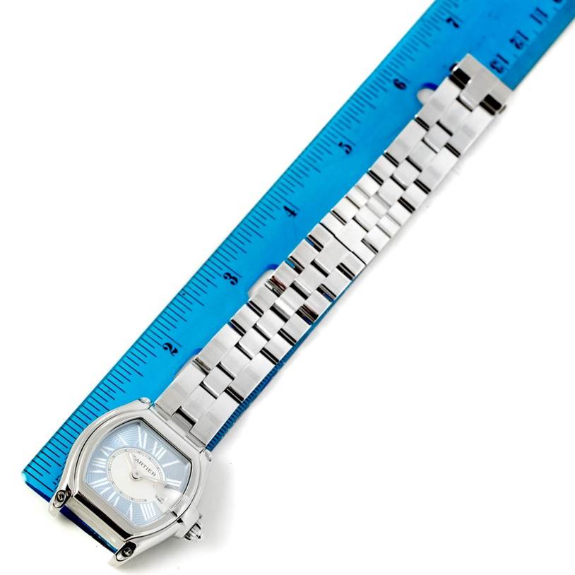 This image shows the Cartier Roadster W62053V3 Women's Stainless Steel Blue Dial W62053V3 Women's Stainless Steel Blue Dial watch, featuring the face, case, and metal bracelet strap, alongside a blue ruler.