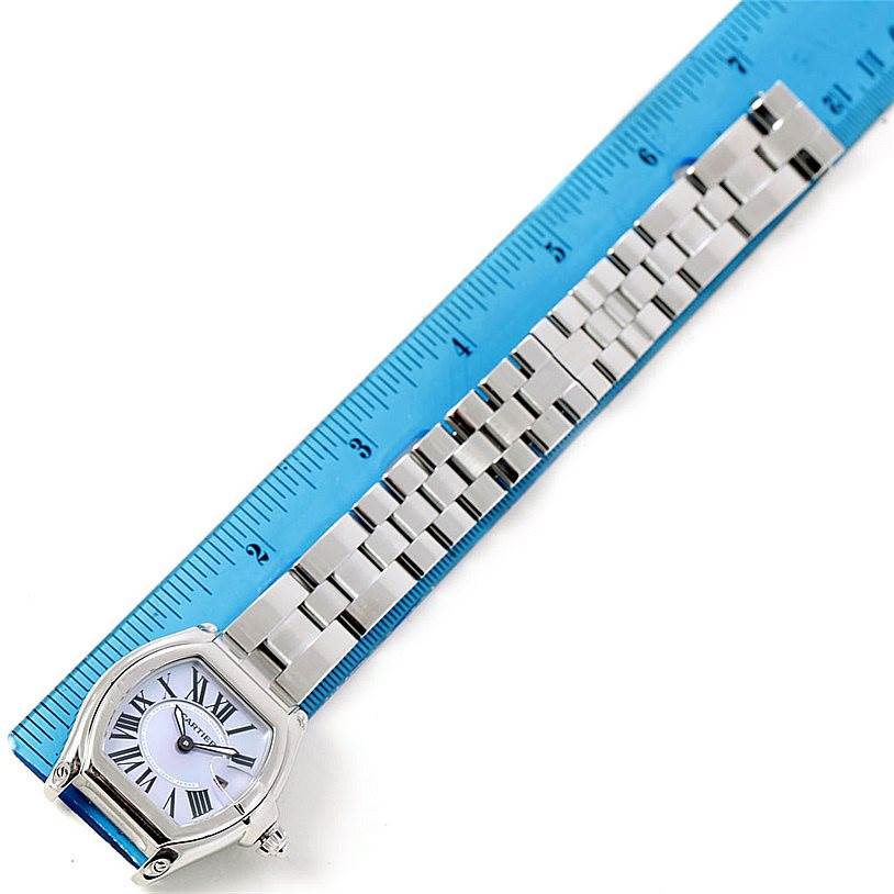 The image shows a Cartier Roadster W6206007 Women's Stainless Steel Mother of Pearl Dial W6206007 Women's Stainless Steel Mother of Pearl Dial watch with a stainless steel band placed next to a blue ruler for scale.