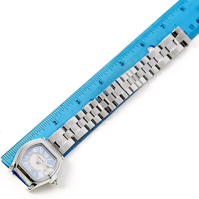 The Cartier Roadster W62053V3 Women's Stainless Steel Blue Dial W62053V3 Women's Stainless Steel Blue Dial watch is shown from a top-down angle, including the face, case, and full bracelet against a blue ruler for scale.